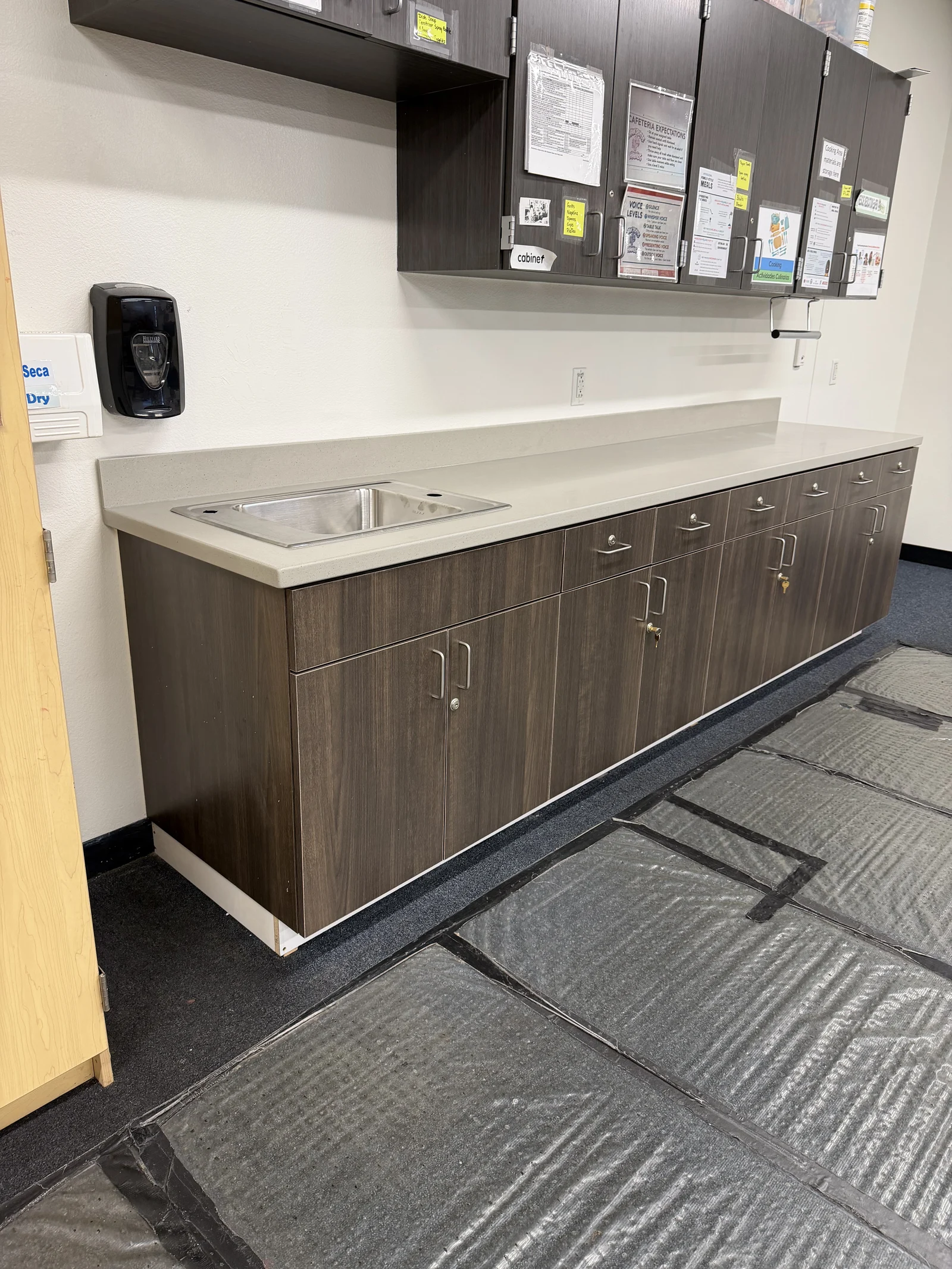 Dark wood-look commercial cabinetry with sink