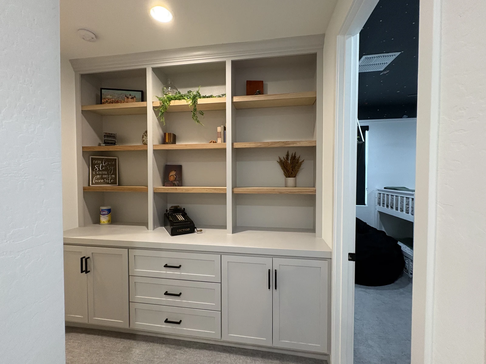Painted hallway display built-in with wood shelves