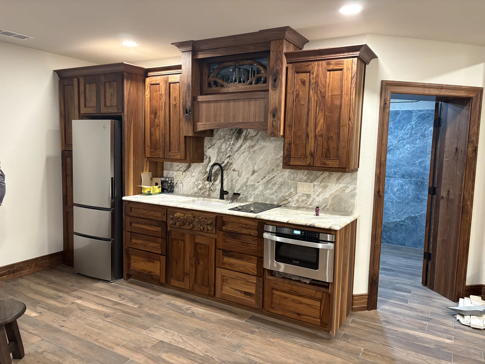 Natural wood kitchen cabinetry with stone counters