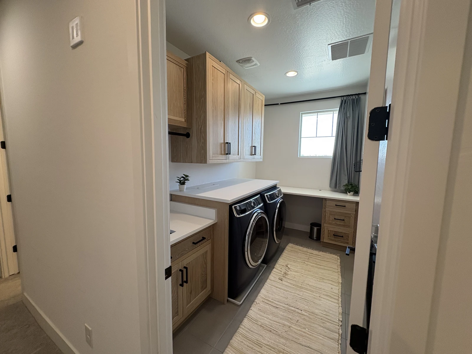 Natural wood laundry room cabinetry and work surfaces