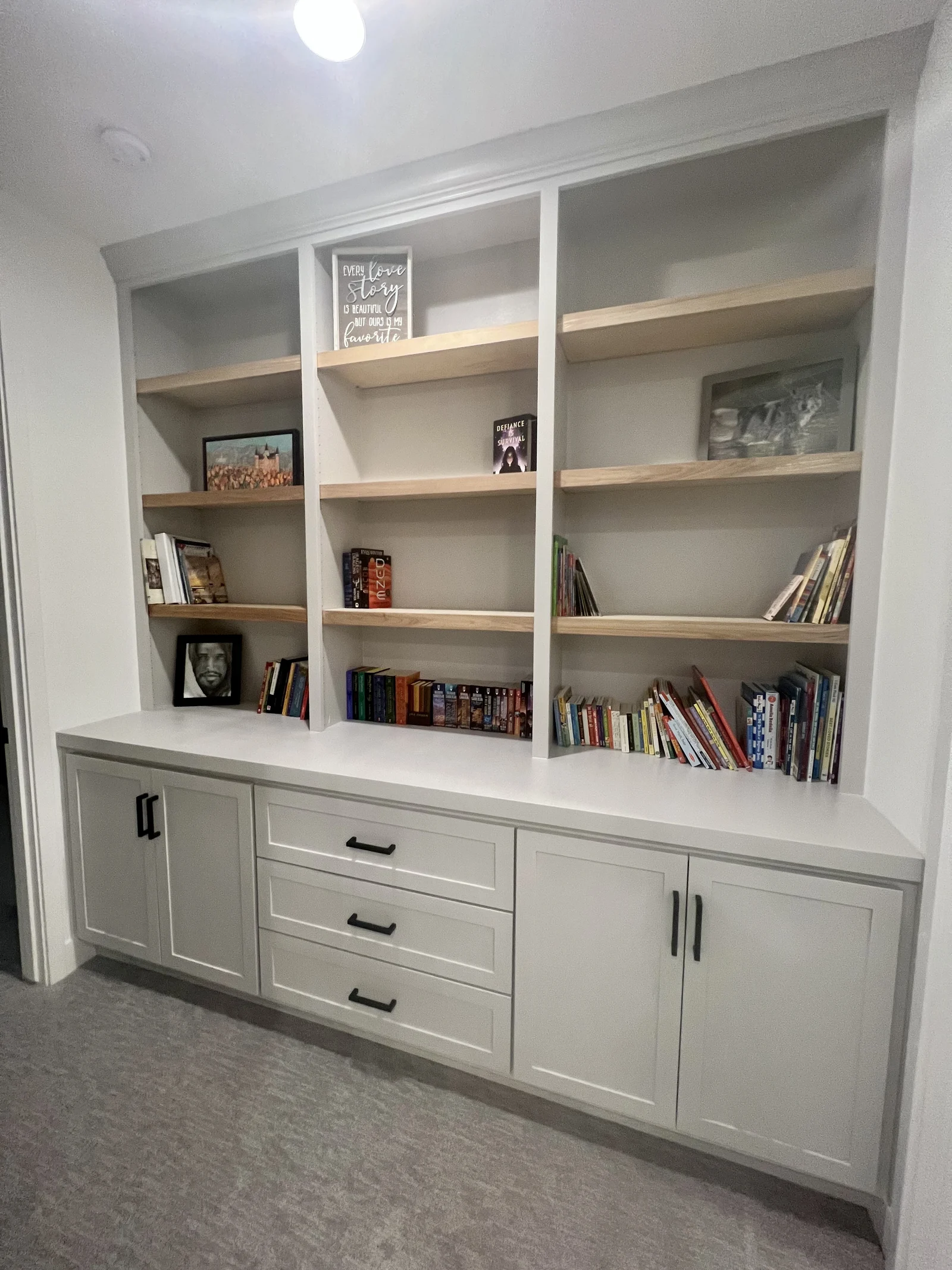 White library built-in with natural wood shelves